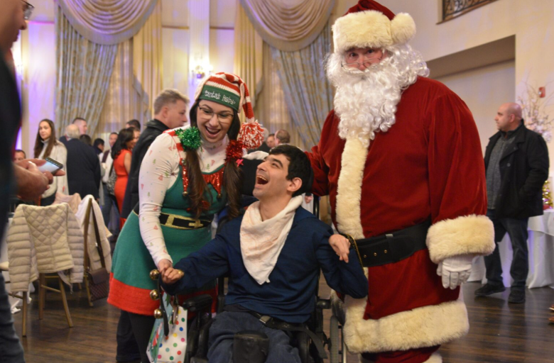 Santa and an elf celebrating with a guest at Operation Santa Claus